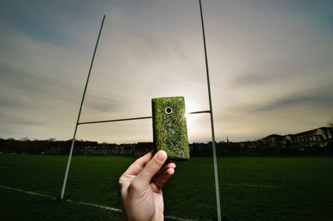 Smartphone s Windows Phone s ekologickým obalem z trávy pořízené z ragbyového hřiště.