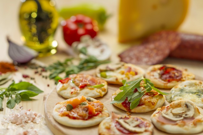There should be light snacks on the table, such as mini pizzas.