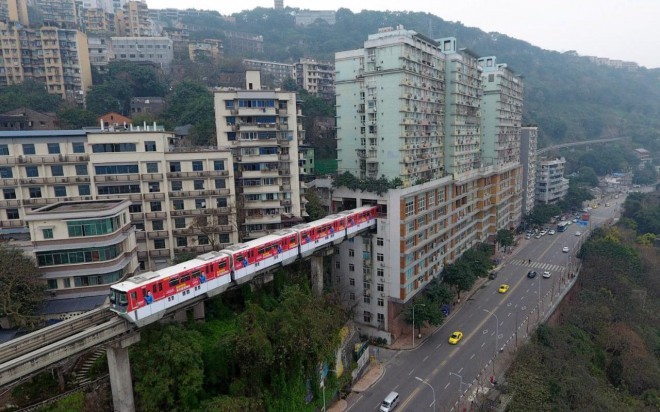 Na Kitajskem vozi vlak kar skozi stanovanja.